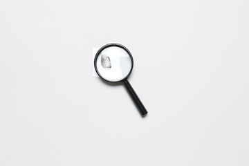 Magnifier and paper with fingerprint on grey background. Detective concept