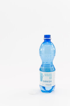 immagine editoriale illustrativa con bottiglia in PET riciclato di acqua minerale naturale su superficie bianca come sfondo