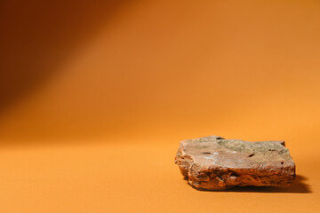 Decorative stone podium on brown background