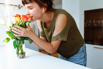 Portrait girl with bouquet of multi-colored roses at home