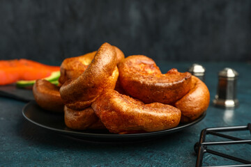 Plate with tasty Yorkshire pudding on blue background