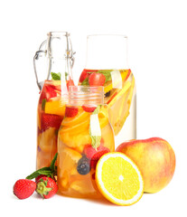 Bottles of infused water with different sliced fruits on white background