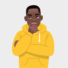 A young black guy with glasses is thinking about something. African successful confident boy in yellow hoodie.