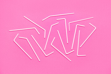 White plastic straws on pink background