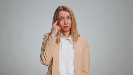 You are crazy, out of mind. Portrait of businesswoman pointing at camera and showing stupid gesture, blaming some idiot for insane plan. Female girl in formal suit. Woman isolated on gray background