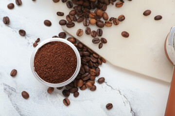 Bowl with coffee powder and beans on white marble background