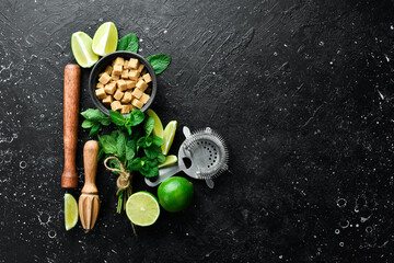 Barware and ingredients for making a Mojito cocktail. On a black background. Top view.