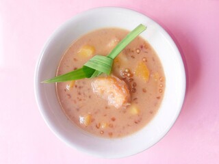 Kolak or compote filled with cassava, banana and pickles. Traditional food from Indonesia. Sweet soup of boiled fruit with a mixture of brown sugar and coconut milk. cream of soup. Top view