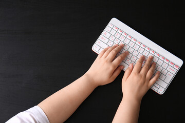 Female hands with modern computer keyboard on dark background