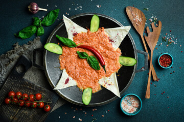 Yumurta with tomatoes. Menemen Turkish breakfast food egg, tomatoes and pepper in pan. Close up. On a dark background.