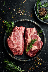 Raw organic marbled beef steaks with spices. On a dark background. Meat. Free space for text.