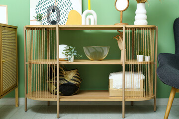 Shelving unit with painting and decor near green wall in room