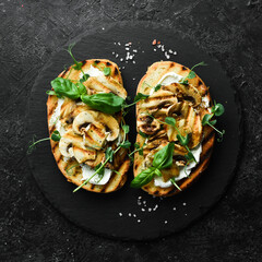 Vegan Sandwich with mushrooms, cheese and basil. Bruschetta. Top view. On a stone background.