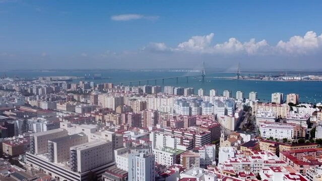 Aerial view over Cadiz coastal cityscape flying towards landmark La Pepa bridge on the Spanish skyline