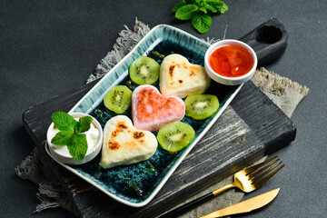 Cheese pancakes in the shape of a heart. Free space for text. Close up.