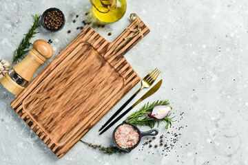 Fototapeta na wymiar Cooking banner. Kitchen wooden board and spices on concrete table. Free space for text. Rustic style.