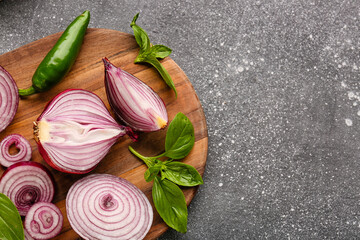 Board with fresh onion, jalapeno and spices on grey background