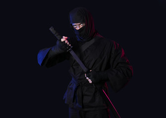 Male ninja with sword on dark background