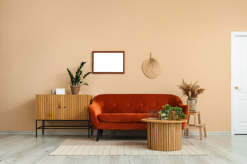 Interior of living room with cozy brown sofa, coffee table and wooden cabinet