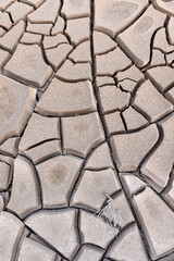 dryness of the earth from the water resulted in the earth becoming stiff and cracking and drying in the soil
