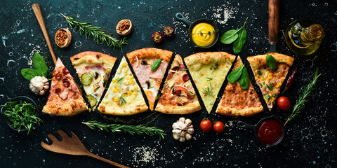 Set of delicious pizza slices and ingredients on black stone background. Top view. Pizza background.