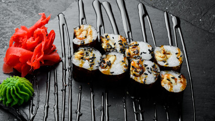 Classic maki rolls. On a black stone background. Top view.