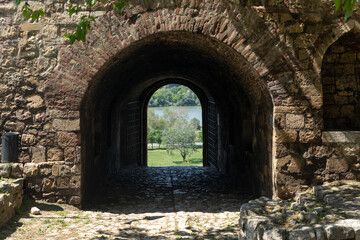 Black motorcycle in front of the old stone wall.