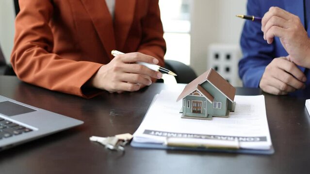 Real estate agent businessman negotiating the terms of the home purchase contract. Signing mortgage contract agreement, rent, lease real estate.
