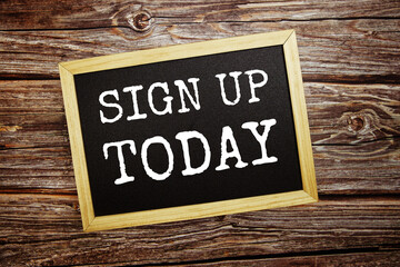 Sign up todaywrite on blackboard top view on wooden background