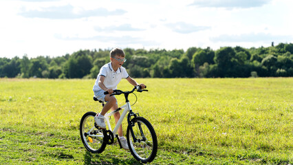 a boy rides a bicycle in nature