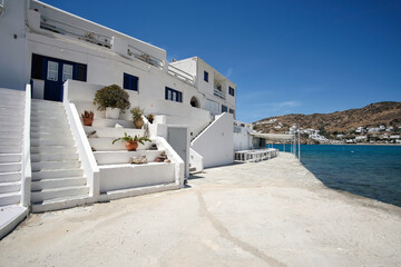 A  whitewashed hotel that rents rooms, with the typical Cycladic architecture,  in front of the  Mylopotas Ios Greece