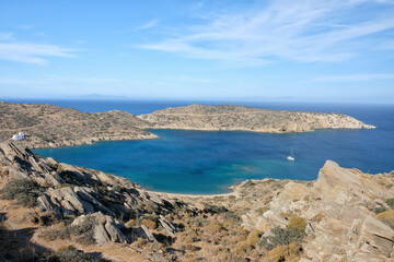 Fototapeta na wymiar Panoramic view of the beautiful Tris klisies beach and a sailboat in Ios Greece