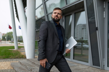 portrait of caucasian male designer walking with documents to business office
