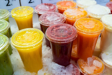 Cold summer natural fruit smoothie drinks in cups with straws. Drinks in the store and in the market. Juice. High quality photo