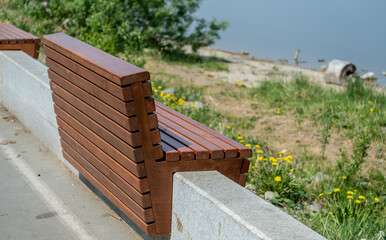 Wooden bench on the parapet on the lake shore.
