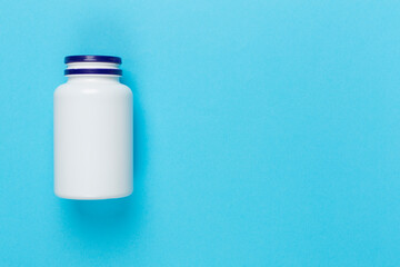 Plastic bottle with vitamins on color background, top view