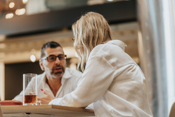 Middle-aged blonde businesswoman listening to her male business partner