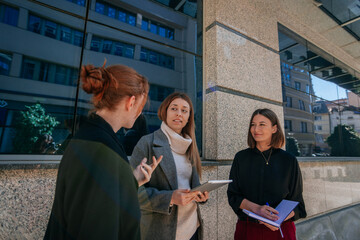 Redhead businesswoman telling a better solution for the problem she has at the project. They are listening to her carefully with slight smile on their face. Seems they like the idea