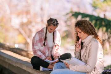 Fototapeta premium Gorgeous curly haired school girl reading book. She is thinking about what she is reading