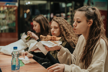Three girls eating pizza