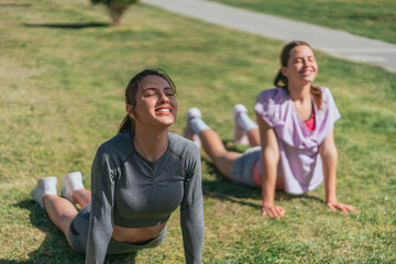 Flexible girls taking care of their bodies. They are warming up before training, stretching their spines