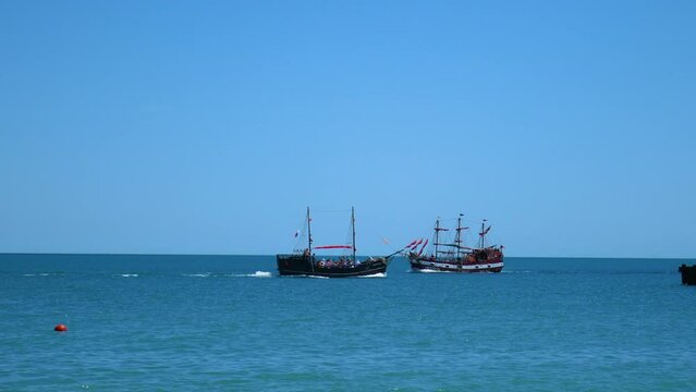 Two ships sail past each other. Old ships, a corvette and a battleship.
