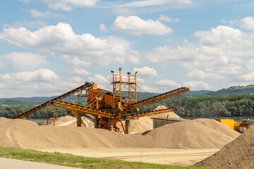 Concrete manufacturing plant and sand piles on the waterfront next to river, sand alluvium.