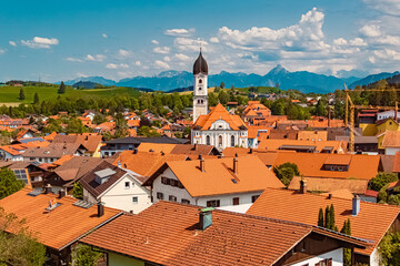 Fototapeta na wymiar Alpine summer view with a church and the alps in the background at Nesselwang, Ostallgaeu, Bavaria, Germany