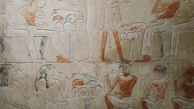 Ancient Egyptian Frescoes on a Stone Wall Depicting People