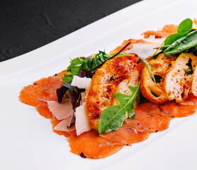 salmon carpaccio served with toast on plate