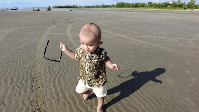 Rohingya child playing on the beach in sand