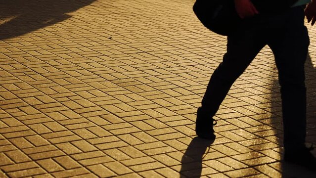 Silhouette of anonymous people walking around the city. Close up, evening