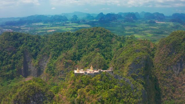 Aerial view Tiger Cave Temple, Buddha on the top Mountain with blue sky of Wat Tham Seua, Krabi,Thailand. Aerial view 4K.