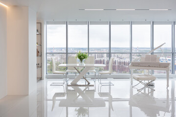 a white and very bright luxury fashionable apartment on a high floor with a free layout, a living room with expensive furniture and panoramic glazing